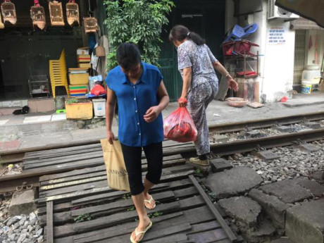 Người dân tự làm các tấm gỗ trải qua đường ray tàu hỏa, để các phương tiện và người đi bộ dễ dàng đi qua.
