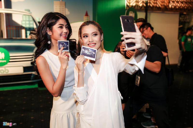 VJ Đàm Phương Linh diện trang phục trắng nữ tính đến ủng hộ chương trình. Cô vui vẻ chụp ảnh cùng á quân Next top cao 1,54 m.