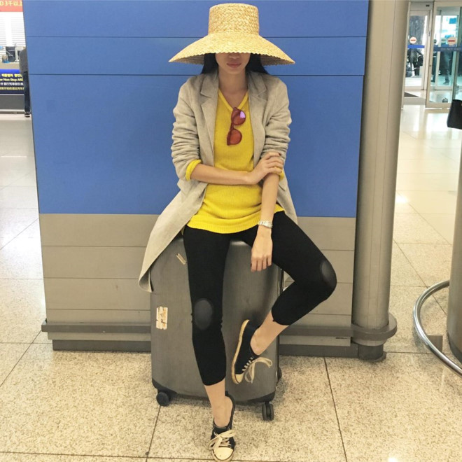 Thanh Trúc gợi ý thời trang du lịch khỏe khoắn với quần legging, áo thun vàng và blazer dáng dài năng động.