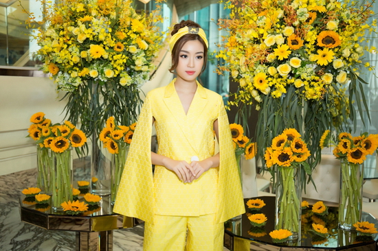 Hoa hậu Việt Nam 2016 Đỗ Mỹ Linh mang đến hình ảnh quý cô thanh lịch khi diện suit cách điệu với phần tay cape, quần âu ống loe rộng. Hoạ tiết của trang phục là những hình lục giác xếp liền kề nhau, xen kẻ những đường màu trắng mỏng manh.