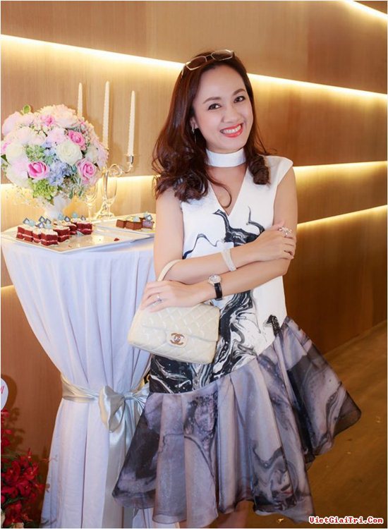 Hoài Anh đi dự sự kiện trong chiếc váy rất độc đáo và tinh tế màu trắng pha họa tiết trừu tượng màu xám đen. Vẫn sử dụng chiếc túi hiệu Chanel quen thuộc, thiết kế váy vạt xéo lệch một bên và vòng cổ trắng tinh dạng Chocker kết hợp với chiếc kính được cài lên mái tóc nâu sóng sánh khiến Hoài Anh thêm phần trẻ trung.