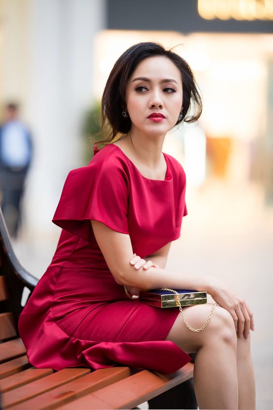 Một Hoài Anh đằm thắm trong sắc đỏ đài các của một thiết kế đồ hiệu. Chiếc váy diềm xếp nếp ở bên hông và clutch ánh kim dạng chữ nhật dây quai xích tiện lợi làm nổi bật lên gương mặt.