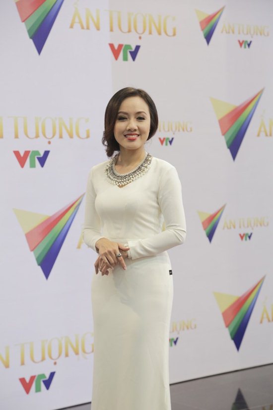 Xuất hiện tại phim trường Ấn tượng VTV, Hoài Anh khoe sự trẻ trung tươi mới trong màu áo dài cách điệu màu trắng tinh khôi. Thiết kế cách điệu này có hàng chục hạt ngọc trai lấp lánh màu trắng và bạc đính trên cổ áo dạng tim. Đôi tay Hoài Anh bắt chéo duyên dáng khoe chiếc nhẫn bạc ton sur ton với vòng cổ. Mái tóc búi nhẹ nhàng tạo nên vẻ thanh thoát hợp với nghề nghiệp của cô.