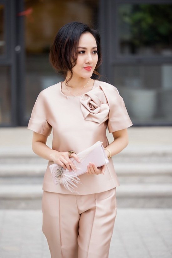 Hoài Anh trong một buổi chụp Lookbook đã diện thiết kế toàn bộ màu hồng be phơn phớt bóng bẩy thiết kế riêng cho cô. Tạo hình hoa hồng 3D trên phần thân trái của áo là điểm nhấn nổi bật nhất. Ngoài ra chiếc clutch cầm tay đính lông vũ cũng cùng tông màu với toàn bộ làm cho tổng thể hài hòa mà vô cùng nổi bật.