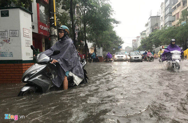 Cơn mưa bắt đầu lúc 7h30 ở nội thành với cường độ lớn ngay lập tức gây xáo trộn giao thông do đúng giờ người dân đi làm. Ảnh: Tiến Tuấn.