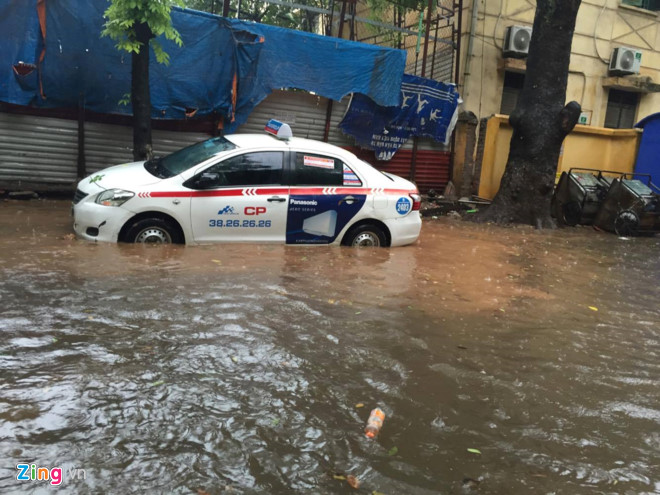 Một chiếc taxi cố leo vỉa hè tránh chỗ ngập sâu trên phố Lương Định Của (quận Đống Đa). Ảnh: Hà Dương.