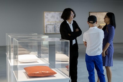 Giám đốc nghệ thuật TS. Mizuki Endo, giám tuyển Quỳnh Phạm đang trao đổi cùng khách tham quan về tác phẩm “Love – tình yêu” của Trương Tân tại triển lãm.