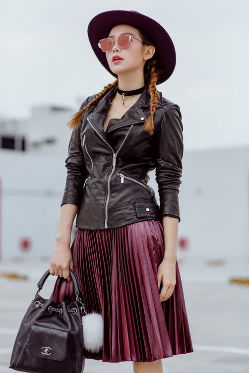 Minh Hằng là một trong những ca sĩ theo đuổi hình ảnh của một fashionista. Trang phục của cô luôn có sự chăm chút và vận dụng nhiều nguyên tắc phối đa dạng. Trong ảnh: cô mặc áo khoác da cùng váy xếp ly và túi bucket hiệu Chanel. 
