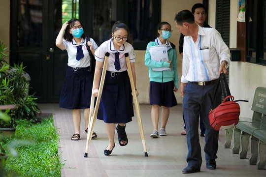 Hình ảnh người cha từ Bình Chánh đưa con gái đi thi tại cụm thi trường THPT Nguyễn Văn Luông (quận 6, TP. HCM) được nhiều người chú ý. Kim Tuyến không may bị tai nạn ở chân và tạm thời chỉ có thể đi lại bằng nạng. Tuy nhiên, nữ sinh vẫn quyết tâm đạt điểm số cao trong kỳ thi THPT quốc gia 2017. Ảnh: 