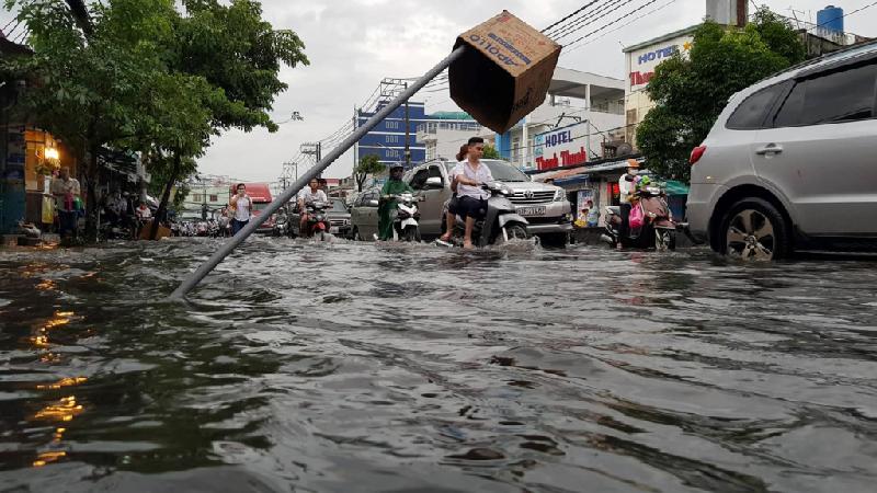 Người Sài Gòn vô tư ngồi uống trà sữa giữa biển nước sau mưa hình ảnh 5 Đường Huỳnh Tấn Phát (quận 7) ngập sâu, nhiều người dùng vật dụng cảnh báo để người dân tránh hố sâu.