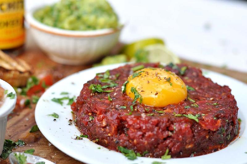 Steak Tartare (Pháp): Món ăn này gồm thịt bò hoặc thịt ngựa sống băm nhỏ, ăn kèm hành, bạch hoa và gia vị, đôi khi có thêm một quả trứng sống. Ảnh: Gran Luchito.