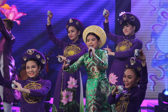  Trong trang phục áo dài truyền thống họa tiết tinh xảo, một tay cầm micro, một tay gõ chum, cô bé 10 tuổi mang đến hình ảnh vô cùng ấn tượng. Hơn nữa, Hiền Trân còn khiến Ban giám khảo “há hốc” với phần biểu diễn xuất thần trong từng câu hát.