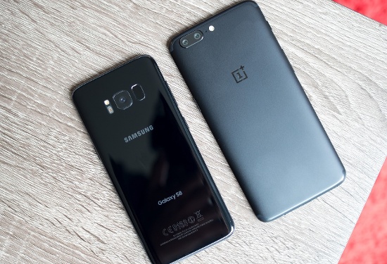Nhìn từ phía trước, chúng ta dễ dàng nhận thấy màn hình của OnePlus 5 có cảm giác lớn hơn (dù thực tế kích thước chỉ 5,5 inch nhỏ hơn so với 5,8 inch trên Galaxy S8) do sử dụng tỷ lệ hiển thị là 16:9, viền màn hình của máy cũng rất mỏng. Tuy nhiên màn hình của Galaxy S8 lại chiếm hết toàn bộ mặt trước và do sử dụng tỷ lệ 18.5:9 nên dù kích thước lớn hơn nhưng lại nhìn nhỏ hơn. 