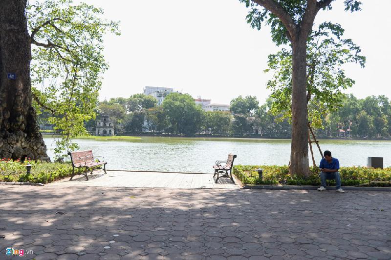 Nhiều người chọn ngồi bên vỉa hè hơn là ngồi trên ghế bị nắng chiếu.