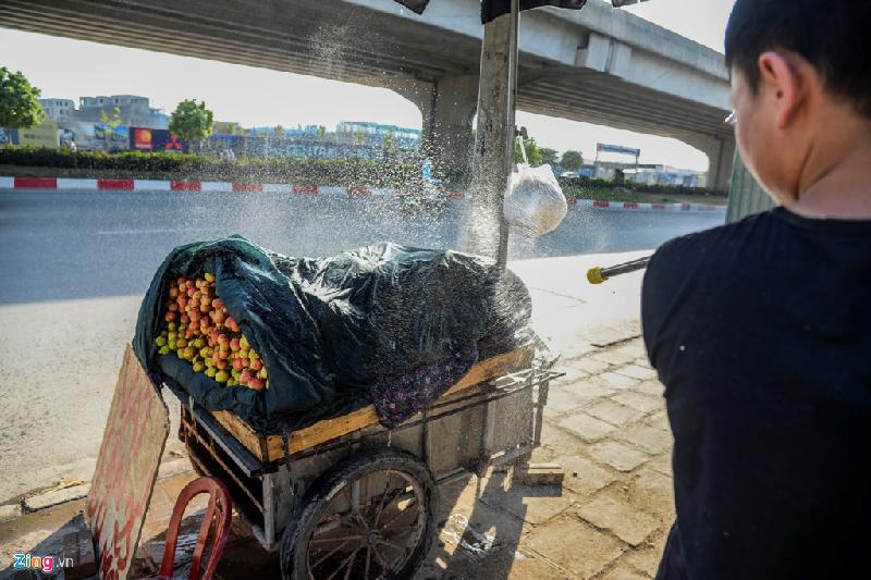 Người bán vải trên đường Khuất Duy Tiến phải phủ lớp chăn dày và liên tục tưới thêm nước để giữ độ tươi cho vải.