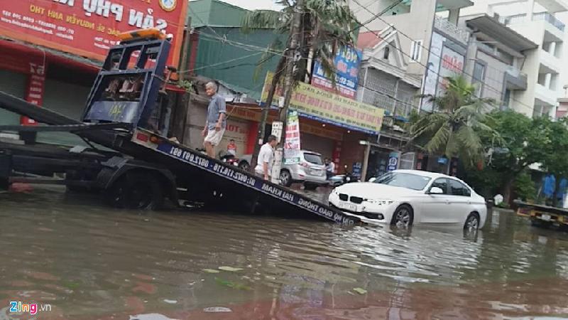 Xe cứu hộ vận chuyển ôtô trên tuyến đường bị ngập sau bão. 