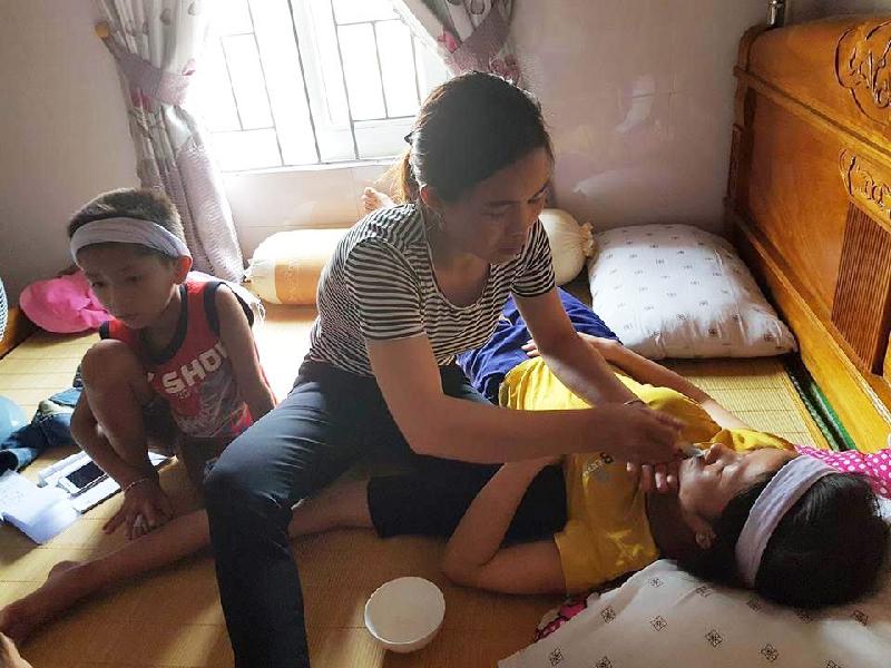 Vợ anh Hùng nằm liệt bên giường, bên cạnh là cậu con trai 6 tuổi.