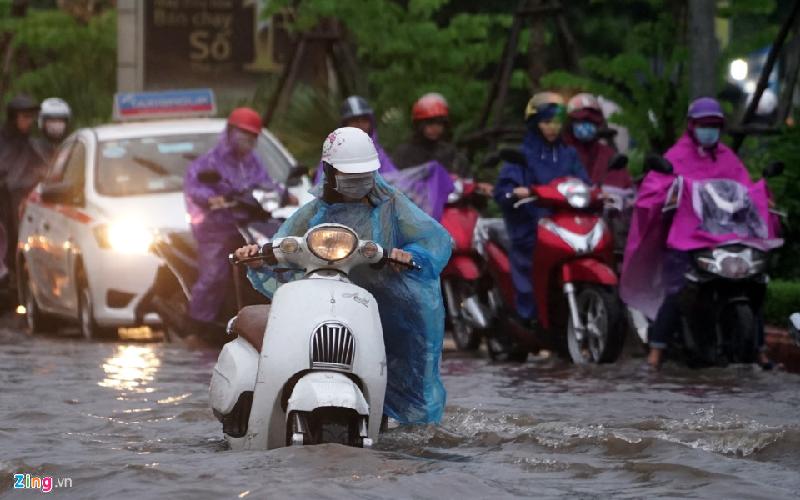 Có người không còn cách nào khác đành dắt bộ qua chỗ ngập. Nếu ngồi lên phóng qua, họ phải có tay lái vững chắc mới đảm bảo không bị sóng đánh ngã. Ảnh: Duy Hiếu.