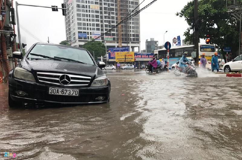 Chiếc Mercedes đang định đỗ lên chỗ cao tránh ngập thì bị vướng mép vỉa hè, tài xế loay hoay điều khiển. Ảnh: 