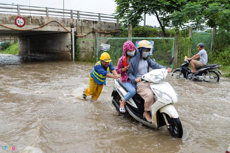 Công nhân thoát nước làm việc tại đây liên tục phải hỗ trợ giúp người đi đường đẩy xe thoát khỏi đoạn ngập sâu. “Từ sáng đến giờ chúng tôi phải đẩy khá nhiều xe bị chết máy dù đã có biển báo hướng dẫn đi vào làn đường khác. Mọi người không tuân theo hướng dẫn muốn đi nhanh cuối cùng xe lại hỏng mất thêm nhiều thời gian”, anh Lưu Đình Hà - công nhân Xí nghiệp Thoát nước Số 6 than thở.