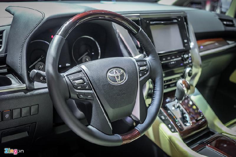 Vô lăng 4 chấu bọc da, ốp gỗ, tích hợp nhiều phím bấm chức năng. Alphard trang bị những kết nối tiêu chuẩn như Bluetooth, điều khiển bằng giọng nói, giúp người lái có thể nhận/gọi điện thoại an toàn khi chạy xe.