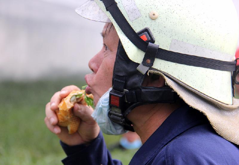 Các chiến sĩ ăn vội bánh mì sau khi ngọn lửa cơ bản được khống chế. Nhiều chiến sĩ mệt lả sau nhiều giờ chiến đấu với giặc lửa.