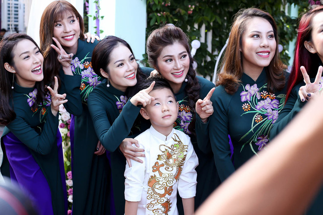 Cà Phao được mẹ cho mặc bộ áo dài cách tân được in hình rồng phượng trên thân áo.