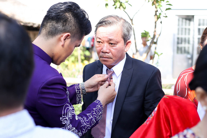 Chú rể tranh thủ chỉnh trang lại trang phục cho bố.