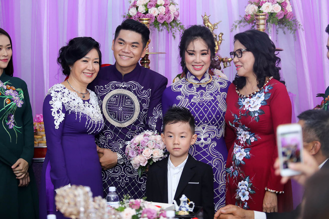 Cô dâu chú rể diện áo dài thêu hoa văn của nhà thiết kế Minh Châu. Cả hai lắng nghe lời dặn dò của cha mẹ hai bên.