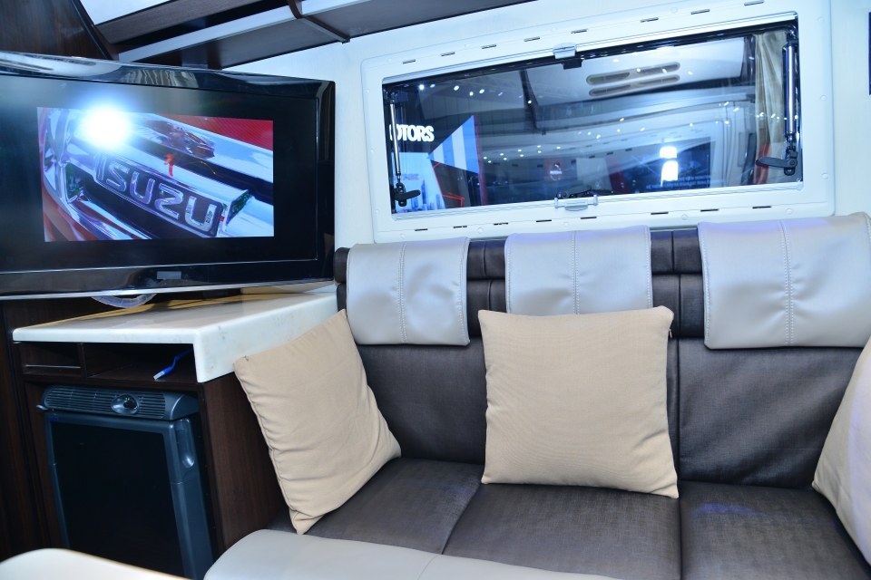 Phòng khách trung tâm khá ấn tượng với một bộ ghế sofa hiện đại bọc nỉ và vải simili, người dùng có thể điều chỉnh linh hoạt thành một giường ngủ phía sau.