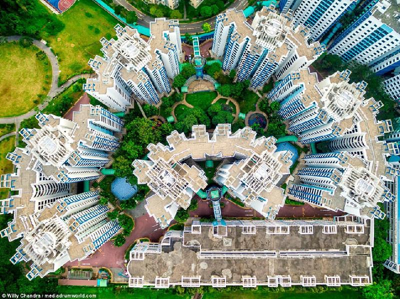 Các công trình kiến trúc được thiết kế hài hòa với cảnh quan, như khu chưng cư này. Màu xanh nhạt của tòa nhà được màu đỏ của nền sân và màu xanh đậm của cây cối tôn lên.