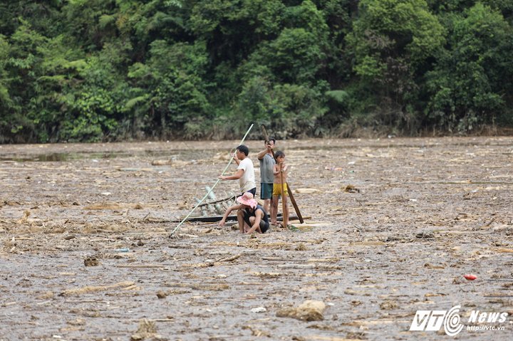Dòng lũ quét đã cuốn đồ đạc, gia súc, gỗ và nhiều người dân xuống khu vực hồ thuỷ điện Mồ Dề. Trên hồ, nhiều gia đình đang tìm kiếm người thân mất tích, nhưng theo người dân ở đây thì việc tìm kiếm sẽ rất khó khăn. (Ảnh: Phong Sơn)