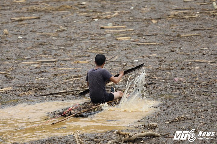 Những người đàn ông sẽ trèo bè ra xa hoặc nếu gần có thể bơi, dùng phao. Họ luôn mang theo một sợi dây để buộc củi cho mẹ, vợ kéo vào bờ. (Ảnh: Phong Sơn)