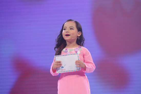 “Bà nhỏ” Minh Anh 5 tuổi tiếp tục “đốn tim” khán giả khi trổ tài làm MC trong chương trình ca nhạc theo chủ đề. Với tà áo dài thướt tha, mái tóc buông dài, cô bé khiến người xem liên tưởng đến hình ảnh nữ MC nổi tiếng Quỳnh Hương. 