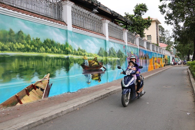 Quê hương ba miền, với sông nước, những chiếc thuyền nhỏ... đều được các bạn luân phiên thể hiện trên bức tường dài 60 mét. ẢNH: THANH TUYỀN.