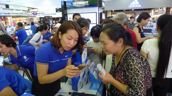 Nhân viên VinaPhone hướng dẫn khách hàng cài ứng dụng VinaPhone Plus trên smartphone.