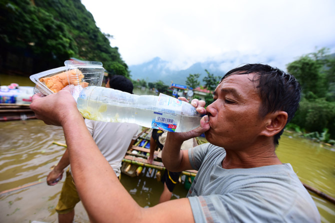 Anh Lò Văn Tĩnh dùng bè giúp người dân di chuyển sang đầu bên kia và ngược lại. Từ sáng anh chở được hơn chục chuyến.