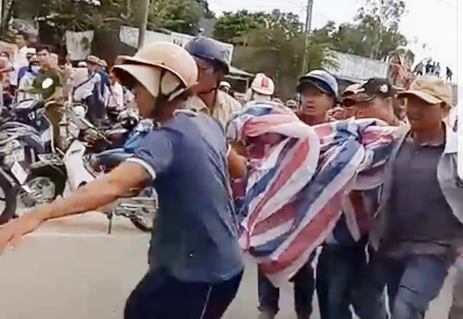 Người dân An Thới dùng bạt quấn nạn nhân lại để đưa lên xe cấp cứu. Ảnh: Mộng Tuyền.