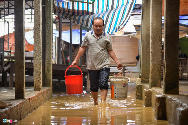 Nước đọng trong chợ bốc mùi hôi thối và đặc sệt bùn đất nhưng các tiểu thương vẫn phải lấy nước đó để rửa vì không còn nguồn nào khác.