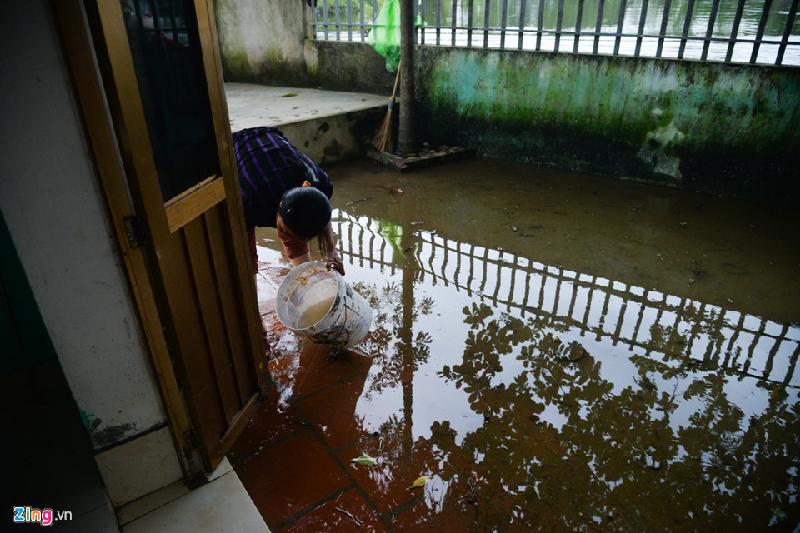 Chị Hiền cũng múc nước ở sông cạnh nhà để rửa cánh cửa: “Nước rút đến đâu lộ ra bùn đất đến đấy, không rửa nhanh lúc nó khô khó rửa hơn”.