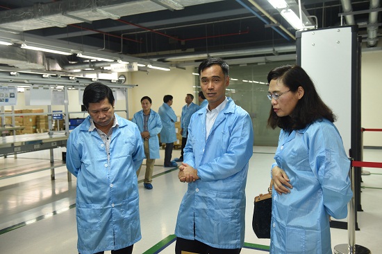 Ông Đỗ Vũ Anh - Thành viên Hội đồng thành viên Tập đoàn VNPT (đứng giữa) đi cùng khách  tham quan