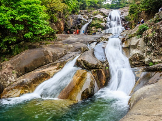 Con đường dẫn vào thác Khe Vằn uốn lượn như dải lụa trắng mềm mại bao lấy những ngôi nhà ven đồi, phía bên kia là những thửa ruộng bậc thang đổ dốc thoai thoải hứng tia nắng mặt trời len lỏi qua các tán rừng xanh, cùng vài chú trâu lững thững gặm cỏ khiến nhiều du khách đứng lắng để ngắm nhìn khung cảnh trữ tình, thơ mộng ấy.