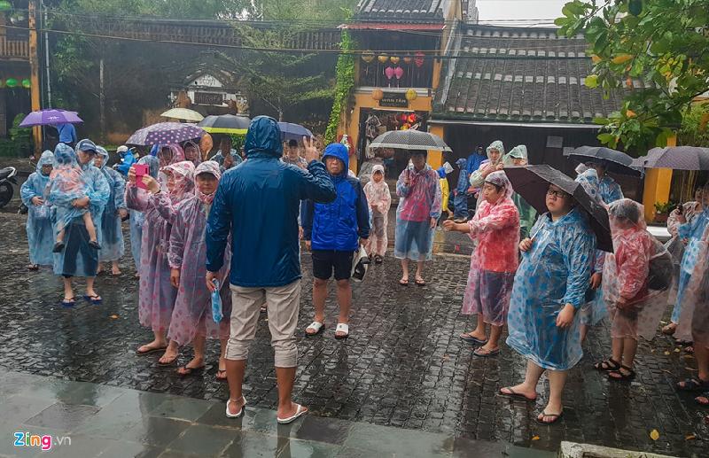 Trên hình là một nam hướng dẫn viên đang giới thiệu do nhóm du khách nước ngoài khi đến tham quan phố cổ Hội An.