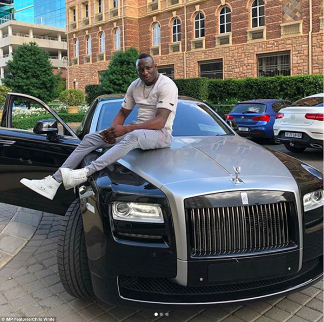 Genius Kandungure ngồi trên nắp ca-pô chiếc Rolls-Royce. Doanh nhân này khiến nhiều người nghi ngờ khi đạt được nhiều hợp đồng lớn cung cấp khí gas cho Zimbabwe nhờ mối quan hệ với Angola Airlines.